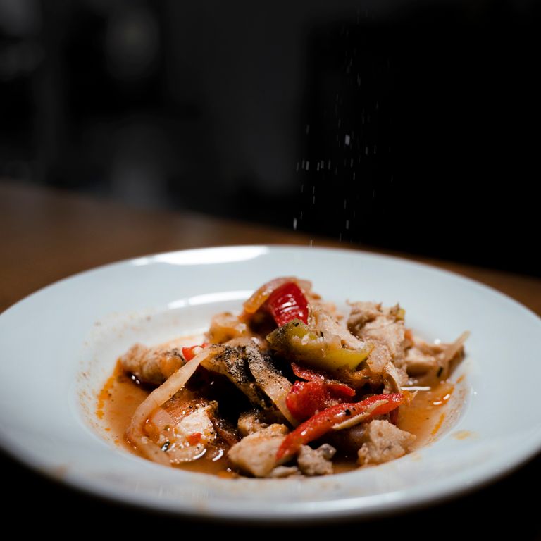A tantalizing close-up of a gourmet meat and vegetable dish served on a white plate.